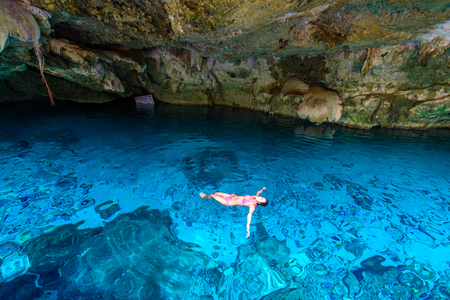 Cenote Dos Ojos in Quintana Roo, Mexico. People swimming and snorkeling in clear blue water. This cenote is located close to Tulum in Yucatan peninsula, Mexico.の写真素材