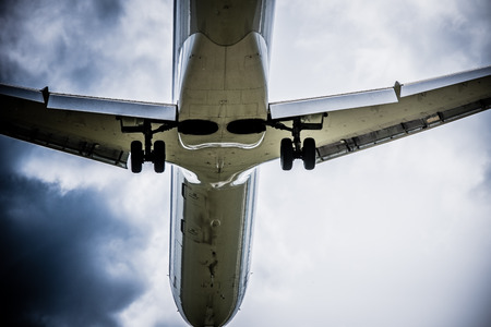 Airplane flying with clouds in backgroundの写真素材