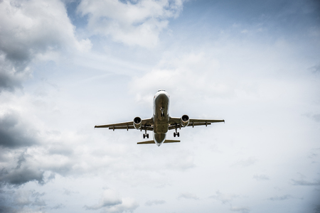 Airplane flying with clouds in backgroundの写真素材