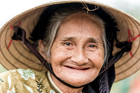 Old friendly woman with vietnamese straw hatのeditorial素材