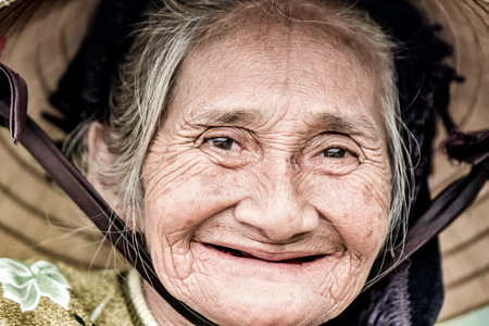 Old friendly woman with vietnamese straw hatのeditorial素材