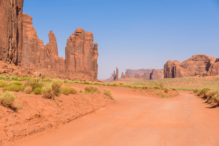 Scenic Drive on Dirt Road through Monument Valley, The famous Buttes of Navajo tribal Park, Utah - Arizona, USA. Scenic road and red rock formations.の写真素材