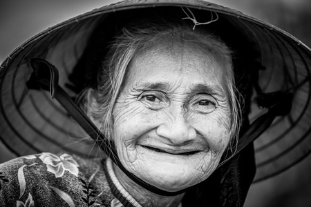 Old friendly woman with vietnamese straw hatのeditorial素材