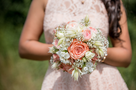 Wedding bouquet - Beautiful flowers in bride's hands in a white dress.の写真素材