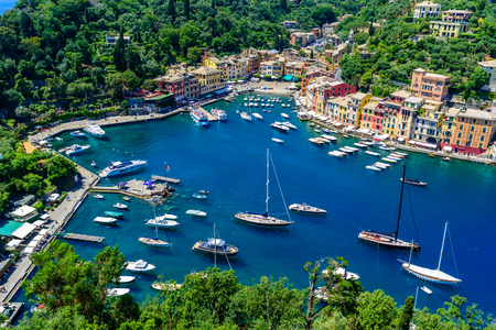 Portofino, Italy - colorful houses and yacht in little bay harbor. Liguria, Genoa province, Italy. Italian fishing village with beautiful sea coast landscape in summer season.の写真素材