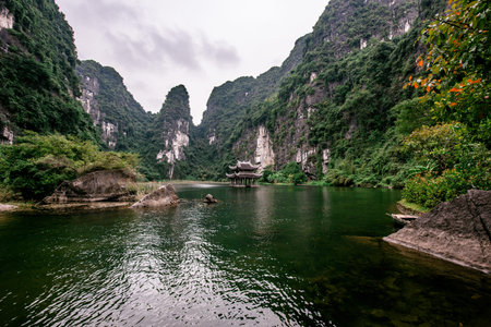 Boat cave tour in Trang An Scenic Landscape formed by karst towers and plants along the river. It's...