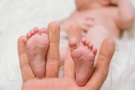 Feet of a newborn baby in the hands of parents. Happy family moment and concept.の写真素材