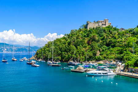 Portofino, Italy - Harbor town with colorful houses and yacht in little bay. Liguria, Genoa province, Italy. Italian fishing village with beautiful sea coast landscape in summer season.の写真素材