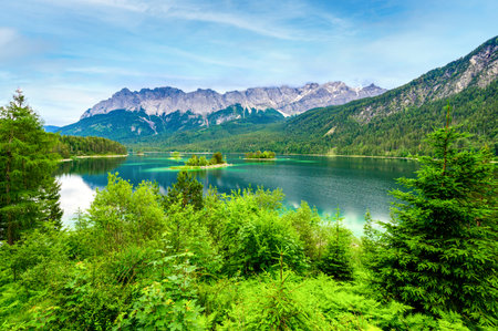 Small islands  pine trees in  middle of Eibsee lake  Zugspitze mountain.