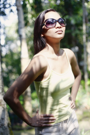 Young Asian Female in a Forest Wearing Sunglasses