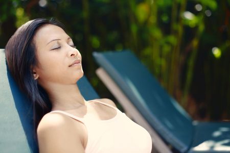 Young Asian Female Relaxing on a Reclining Chairの写真素材