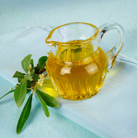 Olive oil with blooming olive branchの写真素材