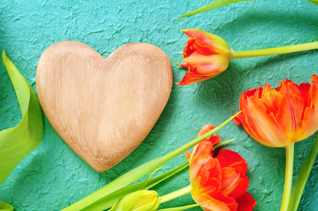 wooden heart and beautiful orange tulipsの写真素材