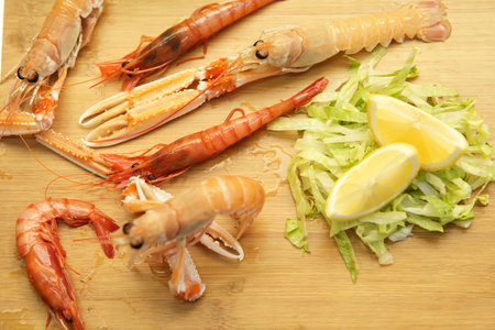 Shrimps on a cutting board with lemon and salad, . Styling cooking. Food photography.の写真素材