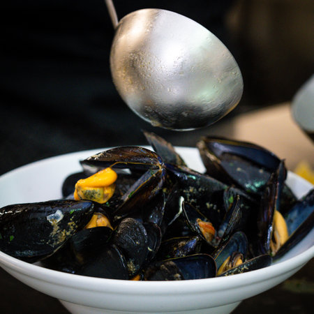 Fresh mussels in a white bowl on a black background. Seafoodの写真素材