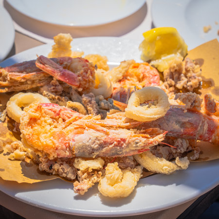 Fried prawns and squid on white plate, Italian food. Restaurant on the beach.の写真素材