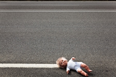 doll leave on a highway lane after car accidentの写真素材