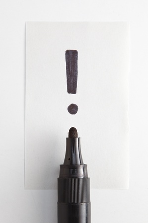 exclamation mark over a black penの写真素材