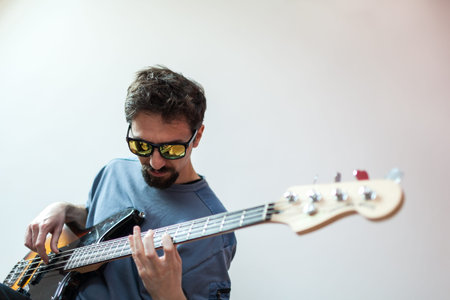 young man play bass with sunglasses