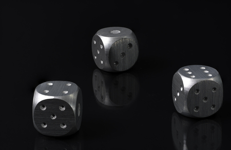 Three Silver Gambling  Dics Laying on black glass with Black Backgroundの写真素材