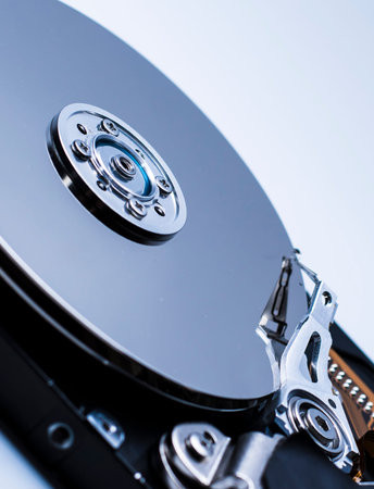 Close up of a Disassembled computer hard drive on white isolated background with reflection