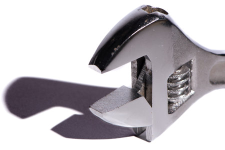 Adjustable crescent wrench with shadow on white background. Abstract concept.
