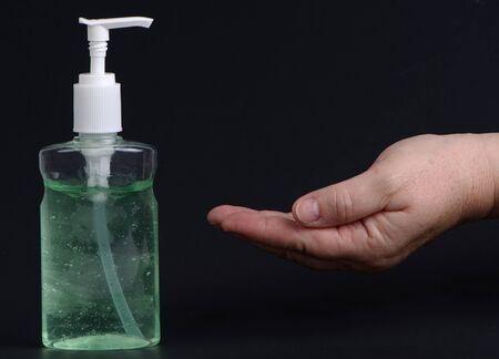 Corona Virus Protection. Hands using hand sanitizer gel pump dispenser. Health concept for killing germs, bacteria and virus. Black background with copy spaceの写真素材