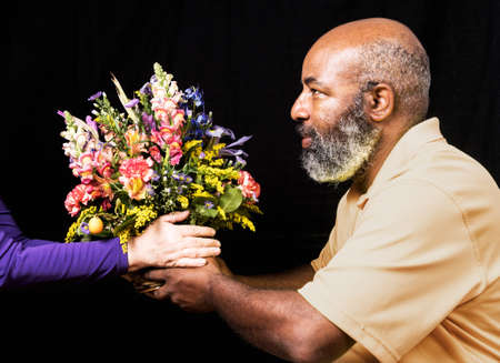 Friendly African American with colorful flower bouquet on black background.  Mothers Day or Valentines Day conceptの写真素材