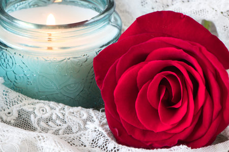 Red rose with purple candle on lace. Spa setting or Motherâs Day and Valentineâs Day concept.の写真素材