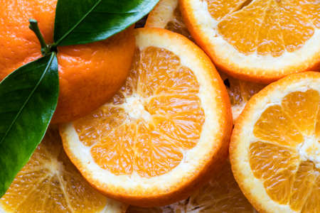 Fresh orange fruit with cut in half slice and green leaf isolated on wood background . Top view. Flat lay. Close upの写真素材