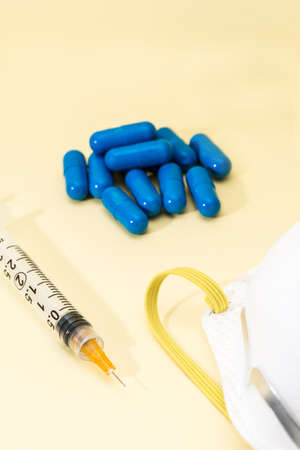 One Covid-19 vaccine vial with mask and a syringe to inject medical professionals and people at risk.. SARS-CoV-2 vaccination treatmentの写真素材