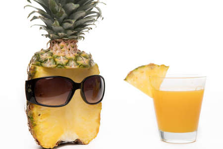 Pineapple half with dark sunglasses and glass on white background for summer holiday funny and vacation conceptの写真素材