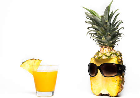 Pineapple half with dark sunglasses and glass on white background for summer holiday funny and vacation conceptの写真素材