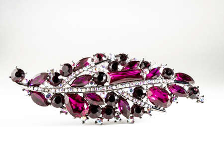 Purple jewelry brooch with white and black stones isolated on white backgroundの写真素材