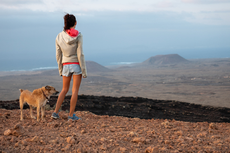 girl on the top of the volcano with her dog, fuerteventura canary islandsの写真素材