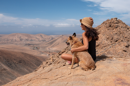 girl watching the panorama with her puppy dog, fuerteventuraの写真素材