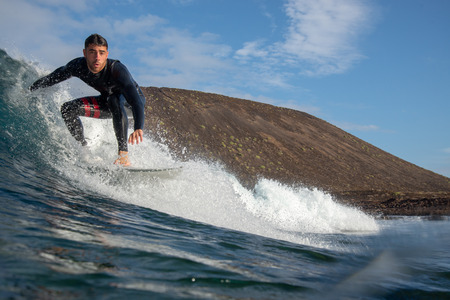 Fuerteventura - March 01, 2019: surfer riding waves on the island of fuerteventura in the Atlantic Oceanのeditorial素材