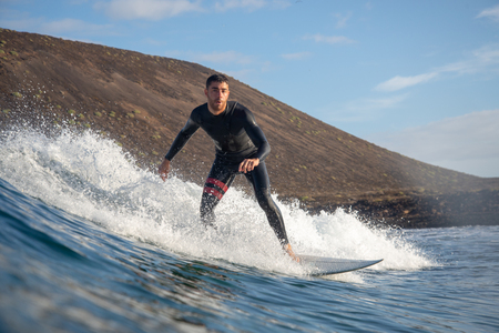 Fuerteventura - March 01, 2019: surfer riding waves on the island of fuerteventura in the Atlantic Oceanのeditorial素材