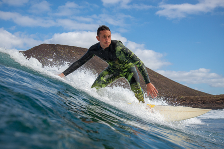 Fuerteventura - March 01, 2019: surfer riding waves on the island of fuerteventura in the Atlantic Oceanのeditorial素材