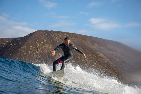Fuerteventura - March 01, 2019: surfer riding waves on the island of fuerteventura in the Atlantic Oceanのeditorial素材