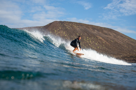 Fuerteventura - March 01, 2019: surfer riding waves on the island of fuerteventura in the Atlantic Oceanのeditorial素材