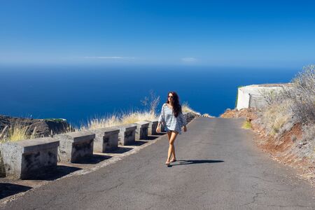 girl walks in the middle of the coastal road, La Palma Islandの写真素材