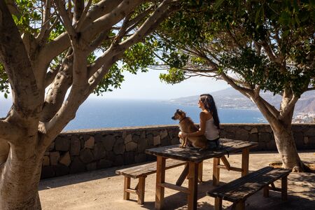 young girl sitting on a picnic tableの写真素材