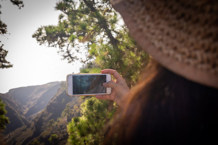 young girl photographs the landscape with her cell phone