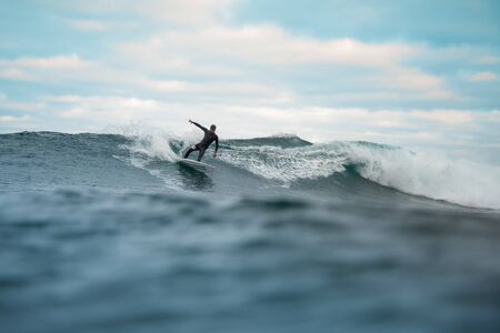 Surfer riding waves on the island of fuerteventura in the Atlantic Ocean, Canary Islandsの写真素材