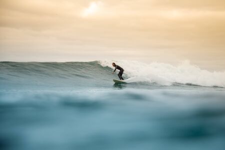 Surfer riding waves on the island of fuerteventura in the Atlantic Ocean, Canary Islandsの写真素材