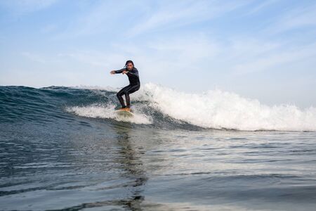 Surfer riding waves on the island of fuerteventura in the Atlantic Ocean, Canary Islandsの写真素材