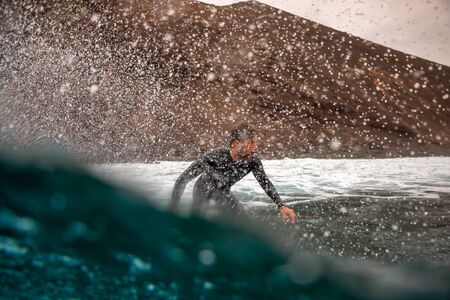 Surfer riding waves on the island of fuerteventura in the Atlantic Ocean, Canary Islandsの写真素材