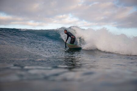 Surfer riding waves on the island of fuerteventura in the Atlantic Ocean, Canary Islandsの写真素材