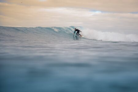Surfer riding waves on the island of fuerteventura in the Atlantic Ocean, Canary Islandsの写真素材
